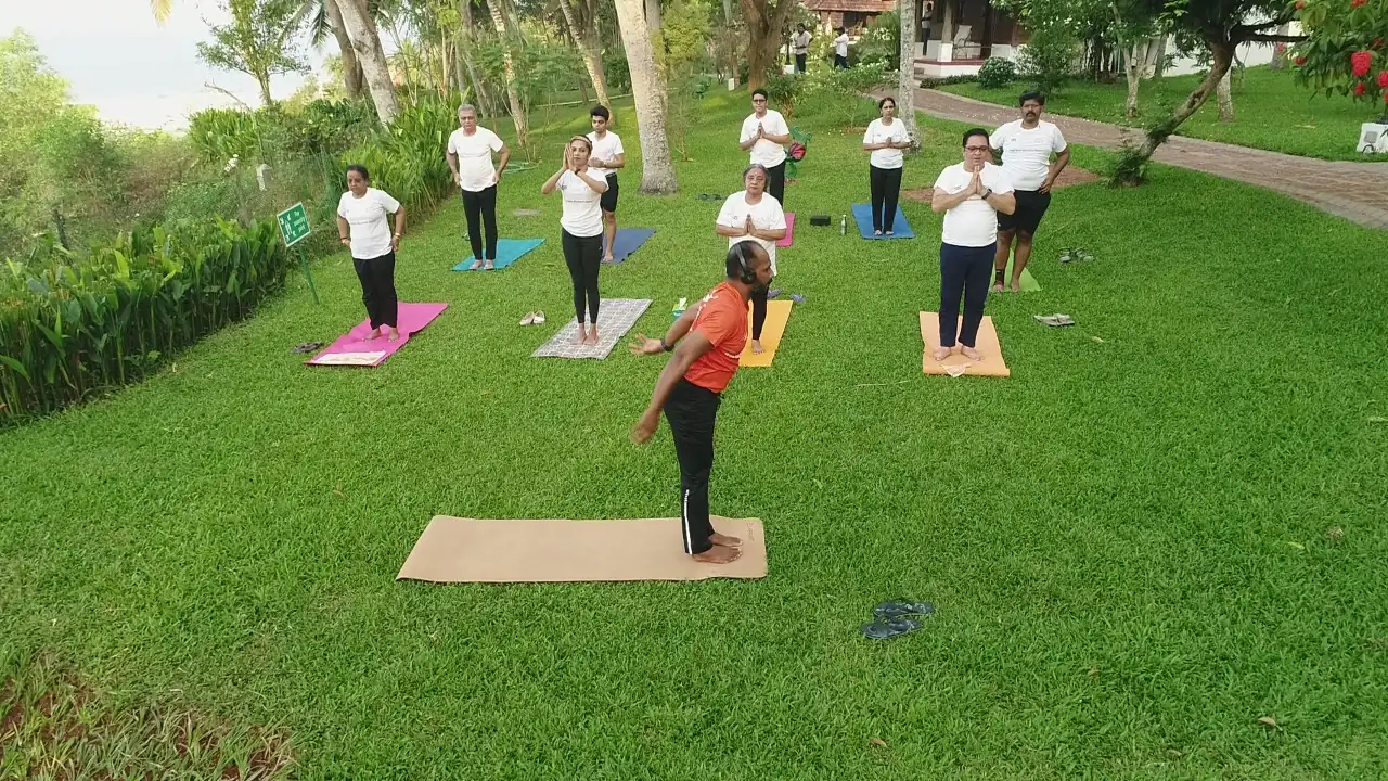 A morning class on the lawn at Kovalam, students on mats while Abhilash demonstrates.