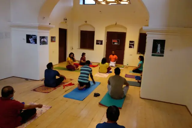 An indoor session, the group seated together in meditation.